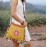 Yellow messenger bag with colorful pompom trim
