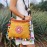 Yellow messenger bag with colorful pompom trim